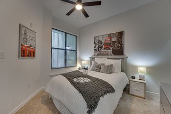 A bedroom with a large bed and a ceiling fan.